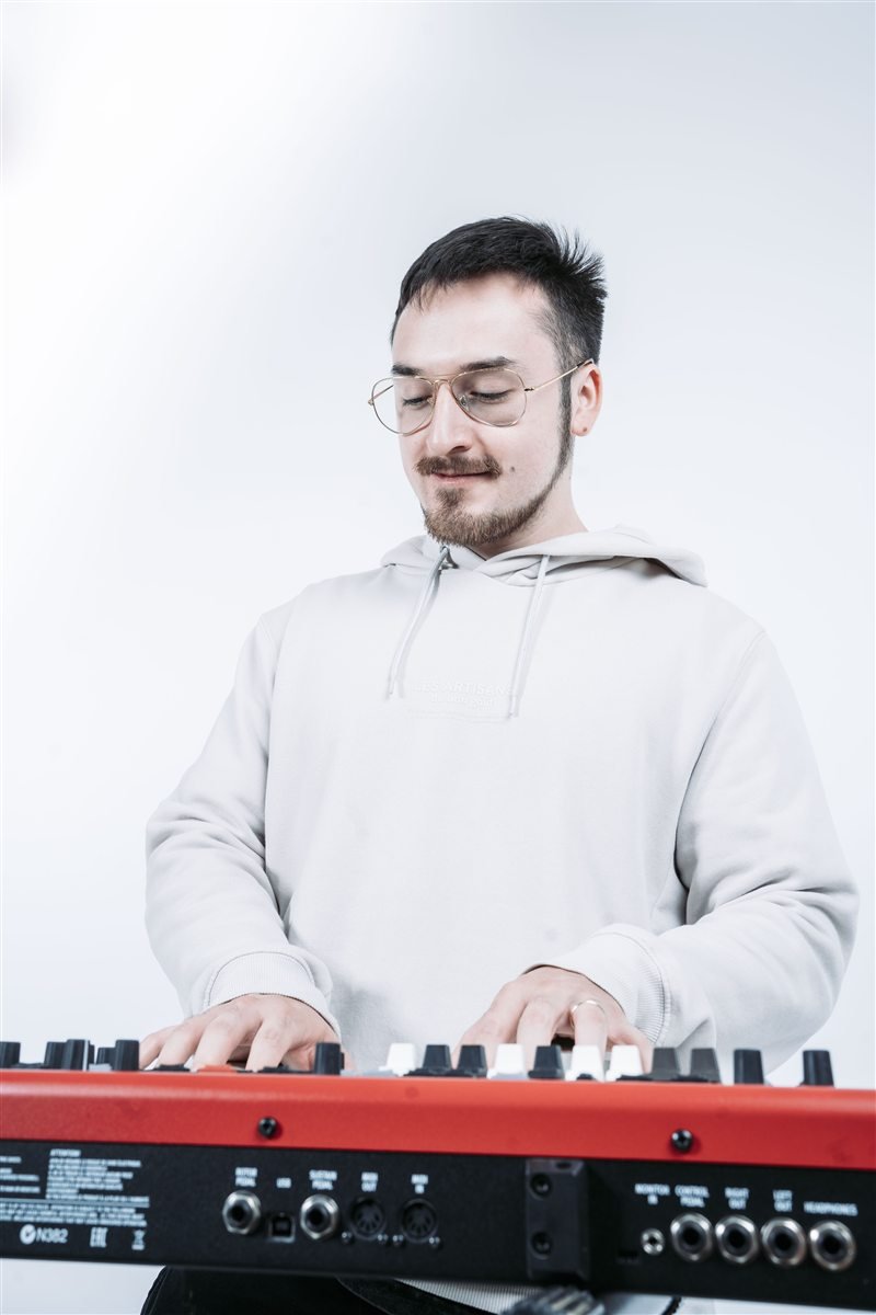 Fundador de Sustento Creativo tocando un teclado Nord Electro en su estudio